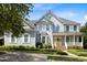 Charming two-story home with a welcoming porch, yellow front door, and professionally landscaped yard at 10513 Cardington Ln, Raleigh, NC 27614