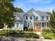 Charming two-story home with a manicured lawn, yellow door, and welcoming front porch at 10513 Cardington Ln, Raleigh, NC 27614