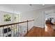 Upstairs hallway featuring hardwood floors, natural light, and views overlooking the downstairs area at 10513 Cardington Ln, Raleigh, NC 27614