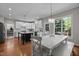 Eat-in kitchen with hardwood floors, white cabinets, stainless appliances, and center island at 10513 Cardington Ln, Raleigh, NC 27614