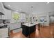 Spacious kitchen featuring a center island with granite countertops, white cabinetry, stainless appliances, and an adjacent dining area at 10513 Cardington Ln, Raleigh, NC 27614