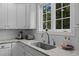 Bright kitchen features granite countertops, white subway tile backsplash, stainless steel sink, and abundant natural light at 10513 Cardington Ln, Raleigh, NC 27614