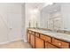 Well-lit bathroom featuring double sinks with granite countertops, wood cabinets, and a glass-enclosed shower at 112 Sabiston Ct, Cary, NC 27519