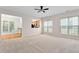 Open concept living room with neutral carpeting, a view of the kitchen and multiple windows at 112 Sabiston Ct, Cary, NC 27519