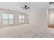 Spacious living room with neutral carpeting, ceiling fan and multiple windows for natural light at 112 Sabiston Ct, Cary, NC 27519