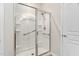 Clean shower featuring a clear glass enclosure, handheld shower head, built-in shelving, and safety bars at 112 Sabiston Ct, Cary, NC 27519