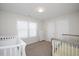 Bright Bedroom with two cribs, white walls, window, and storage unit providing a calming and organized space at 1125 Russet Ln, Apex, NC 27523