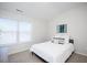 Bright bedroom with white linens and modern decor; with natural light from a large window, relaxing retreat at 1125 Russet Ln, Apex, NC 27523