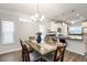 Open concept dining area with wood floors, modern lighting, and an island with bar seating at 1125 Russet Ln, Apex, NC 27523