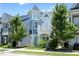 Charming two-story home featuring a unique turret design and colorful accents, flanked by mature trees at 1125 Russet Ln, Apex, NC 27523