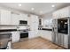 Kitchen featuring granite countertops, stainless steel appliances, white cabinets, and wood floors at 1125 Russet Ln, Apex, NC 27523