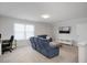 Spacious living room with a comfortable blue sofa, desk, and large window, creating a bright workspace at 1125 Russet Ln, Apex, NC 27523