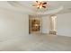 Bedroom with tray ceilings and neutral carpet opens to stairs with rod iron railing at 1148 Survada Ln, Morrisville, NC 27560
