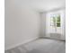 Simple bedroom with neutral carpet and a window providing natural light, creating a relaxing and versatile space at 11548 Helmond Way # 104, Raleigh, NC 27617