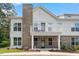 Charming two-story exterior showing a combination of brick and white siding with a quaint balcony and well-maintained landscaping at 11548 Helmond Way # 104, Raleigh, NC 27617