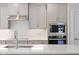 Sleek kitchen featuring stainless steel appliances, light grey cabinetry, and a stylish tile backsplash for a modern aesthetic at 11548 Helmond Way # 104, Raleigh, NC 27617