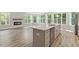Bright, open-concept kitchen and living room with luxury vinyl plank flooring and large windows offering ample natural light at 11548 Helmond Way # 104, Raleigh, NC 27617