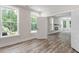 Bright, open-concept living room with a fireplace, luxury vinyl plank flooring and large windows offering ample natural light at 11548 Helmond Way # 104, Raleigh, NC 27617