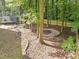 Landscaped backyard with stone-lined flowerbeds, fire pit, and a trampoline at 120 E Laurenbrook Ct, Cary, NC 27518