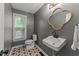 The powder room features patterned floors, gray walls, and a unique gold framed mirror at 120 E Laurenbrook Ct, Cary, NC 27518