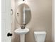 Cozy half bathroom features a pedestal sink and oval mirror, offering a functional space at 129 Middlegreen Pl, Holly Springs, NC 27540