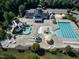 Overhead view of a community pool area with slides, a splash pad, and ample seating at 129 Middlegreen Pl, Holly Springs, NC 27540