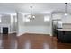 Bright dining area features hardwood floors, chandelier, and view to the kitchen with white cabinetry at 129 Middlegreen Pl, Holly Springs, NC 27540