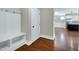 Inviting entryway featuring wood floors, built-in storage, and access to the kitchen at 129 Middlegreen Pl, Holly Springs, NC 27540