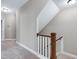 Upstairs hallway with staircase and neutral colored walls and carpet at 129 Middlegreen Pl, Holly Springs, NC 27540