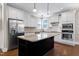 Modern kitchen with stainless steel appliances, white cabinets, and a central island featuring a granite countertop at 129 Middlegreen Pl, Holly Springs, NC 27540