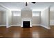 Bright living room with hardwood floors, a classic fireplace, and ample natural light from large windows at 129 Middlegreen Pl, Holly Springs, NC 27540