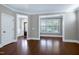 Elegant living room with hardwood floors and detailed trim, offering a seamless flow to other areas at 129 Middlegreen Pl, Holly Springs, NC 27540
