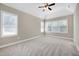 Spacious main bedroom with large windows, neutral paint, carpet, and ceiling fan at 129 Middlegreen Pl, Holly Springs, NC 27540