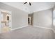 Spacious main bedroom with bathroom access, neutral paint, and carpet at 129 Middlegreen Pl, Holly Springs, NC 27540