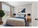Bright bedroom features a queen-sized bed with stylish blue accents and ample natural light from the window at 1313 Littlehills Dr, Apex, NC 27523