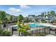 Community pool surrounded by well-manicured landscaping, lounge chairs, and attractive homes under a bright, partly cloudy sky at 1313 Littlehills Dr, Apex, NC 27523
