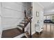 Elegant staircase features dark wood steps, an ornamental banister, and white wainscoting on the walls at 1313 Littlehills Dr, Apex, NC 27523