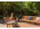 Cozy back deck with comfortable seating, a decorative outdoor fireplace, and surrounded by lush greenery at 1409 Valley, Durham, NC 27707