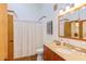 Bathroom featuring a vanity, decorative mirror, shower with curtain, and wood-look trim at 1409 Valley, Durham, NC 27707