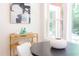 Sunlit breakfast nook with a round table, rattan bar cart, and an abstract painting on the wall at 1409 Valley, Durham, NC 27707