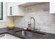 Close-up of a modern kitchen sink with black countertop and sleek, stainless steel fixtures at 1409 Valley, Durham, NC 27707