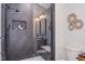 Elegant shower with sleek black fixtures and tiled walls, complemented by a stylish vanity in the background at 1409 Valley, Durham, NC 27707
