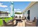 Cozy backyard patio with wicker seating, umbrella, and a fire pit, perfect for outdoor entertaining at 1561 Dorsett Ln, Creedmoor, NC 27522