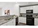 Galley kitchen features granite countertops, stainless sink and black appliances at 1561 Dorsett Ln, Creedmoor, NC 27522