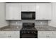White cabinetry, granite countertops, and stainless steel appliances in modern kitchen at 1561 Dorsett Ln, Creedmoor, NC 27522