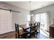 Warm dining area features a rustic table, barn door and sliding glass doors to the outdoor area at 157 E Wilson St, Clayton, NC 27520