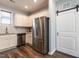 Modern kitchen featuring stainless steel refrigerator, white cabinets and a barn door for style at 157 E Wilson St, Clayton, NC 27520