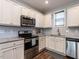Well-equipped kitchen with granite countertops, stainless steel appliances and white cabinetry at 157 E Wilson St, Clayton, NC 27520