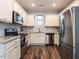 Modern kitchen featuring stainless steel appliances, granite countertops and white cabinetry at 157 E Wilson St, Clayton, NC 27520