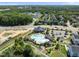 This aerial view shows a community pool and clubhouse surrounded by landscaping, homes and roads at 1604 Upper Park Rd, Wake Forest, NC 27587